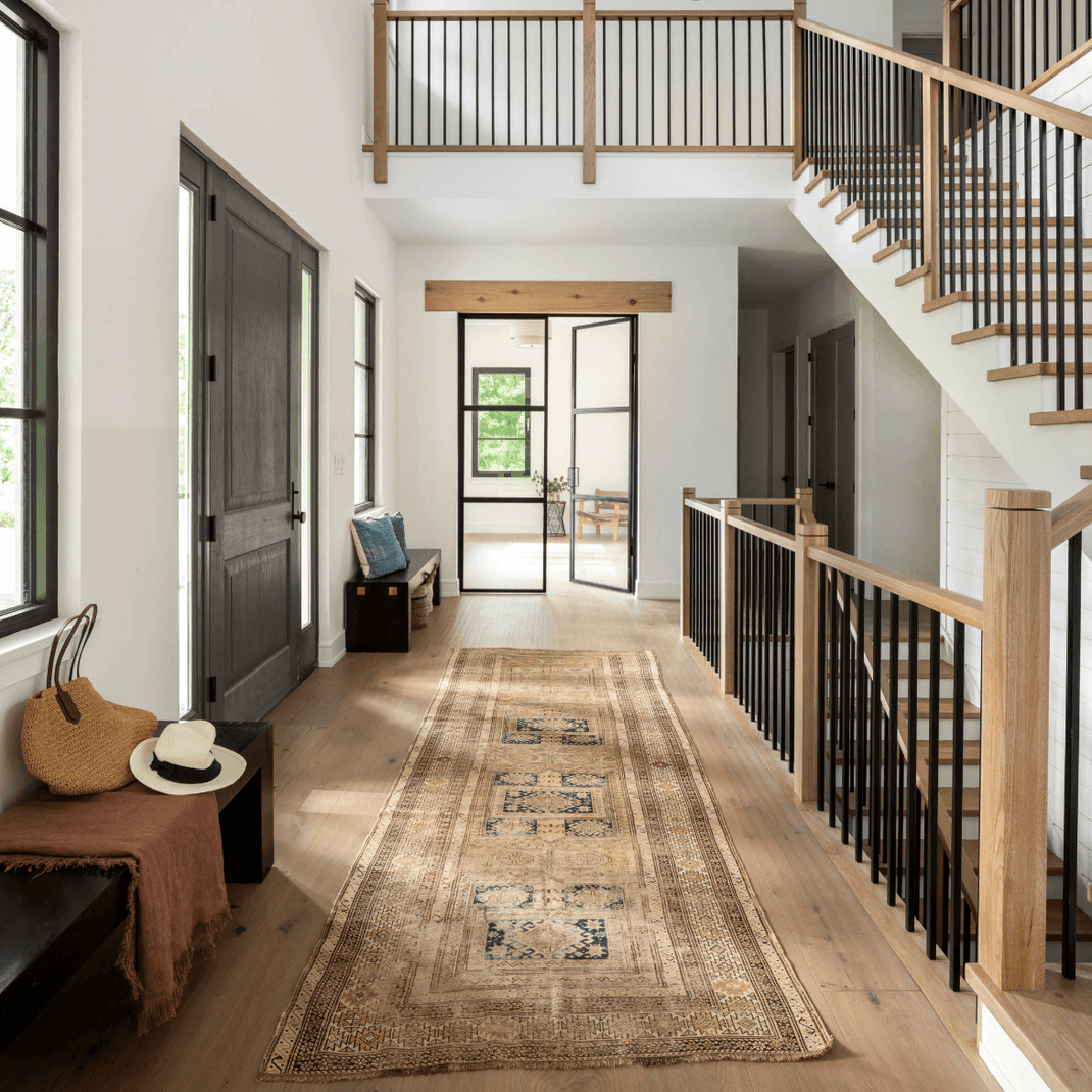 Neutral 10-foot runner rug extending through an upstairs hallway beside a staircase