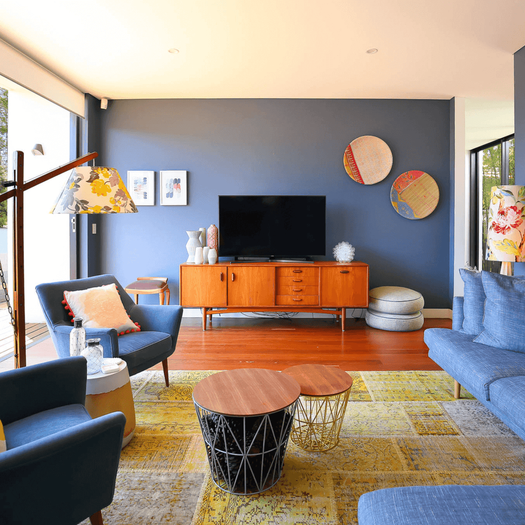 Yellow 10x13 rug beneath the seating area of a contemporary living room with blue furniture