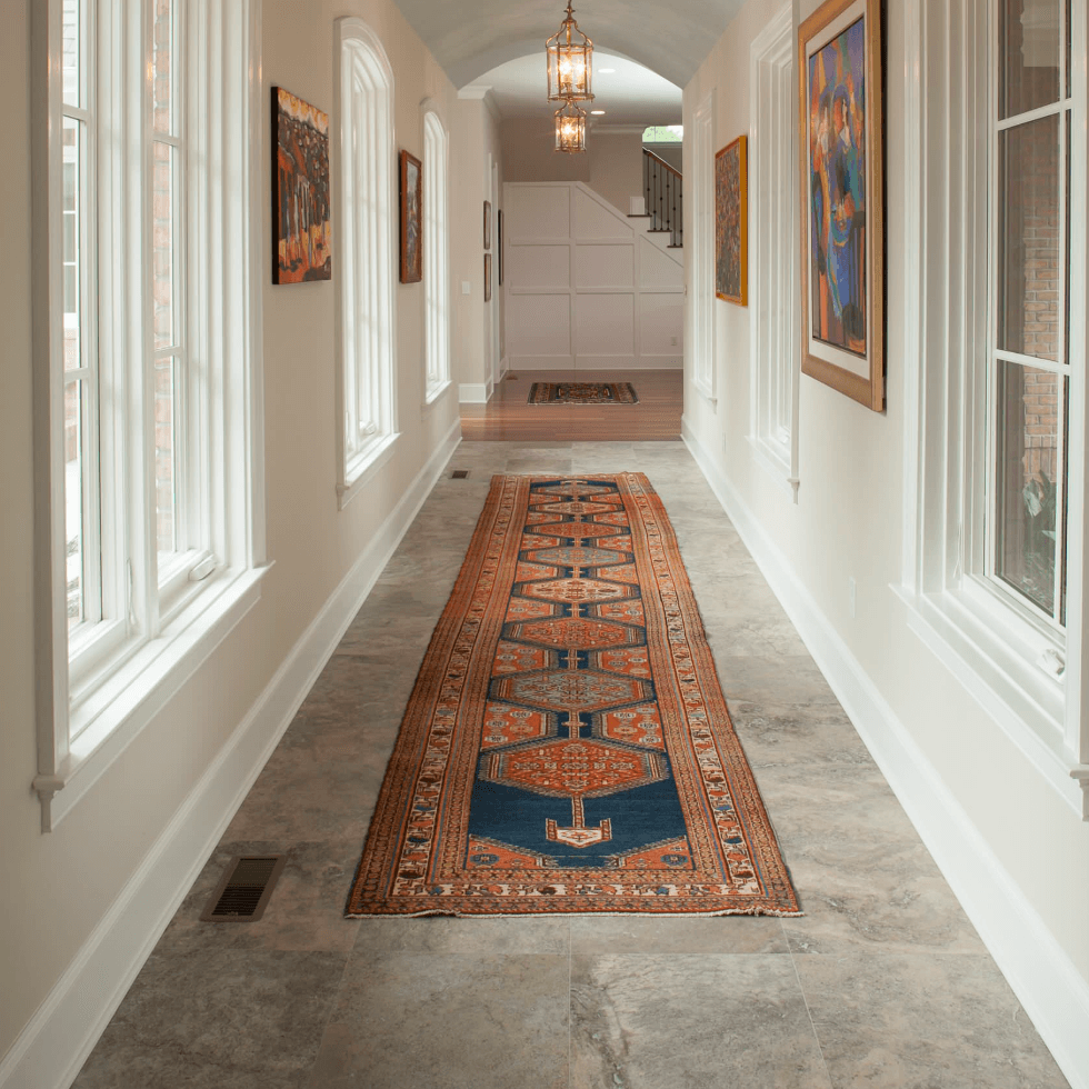 Geometric 11-foot runner rug extending through a bright hallway with large windows