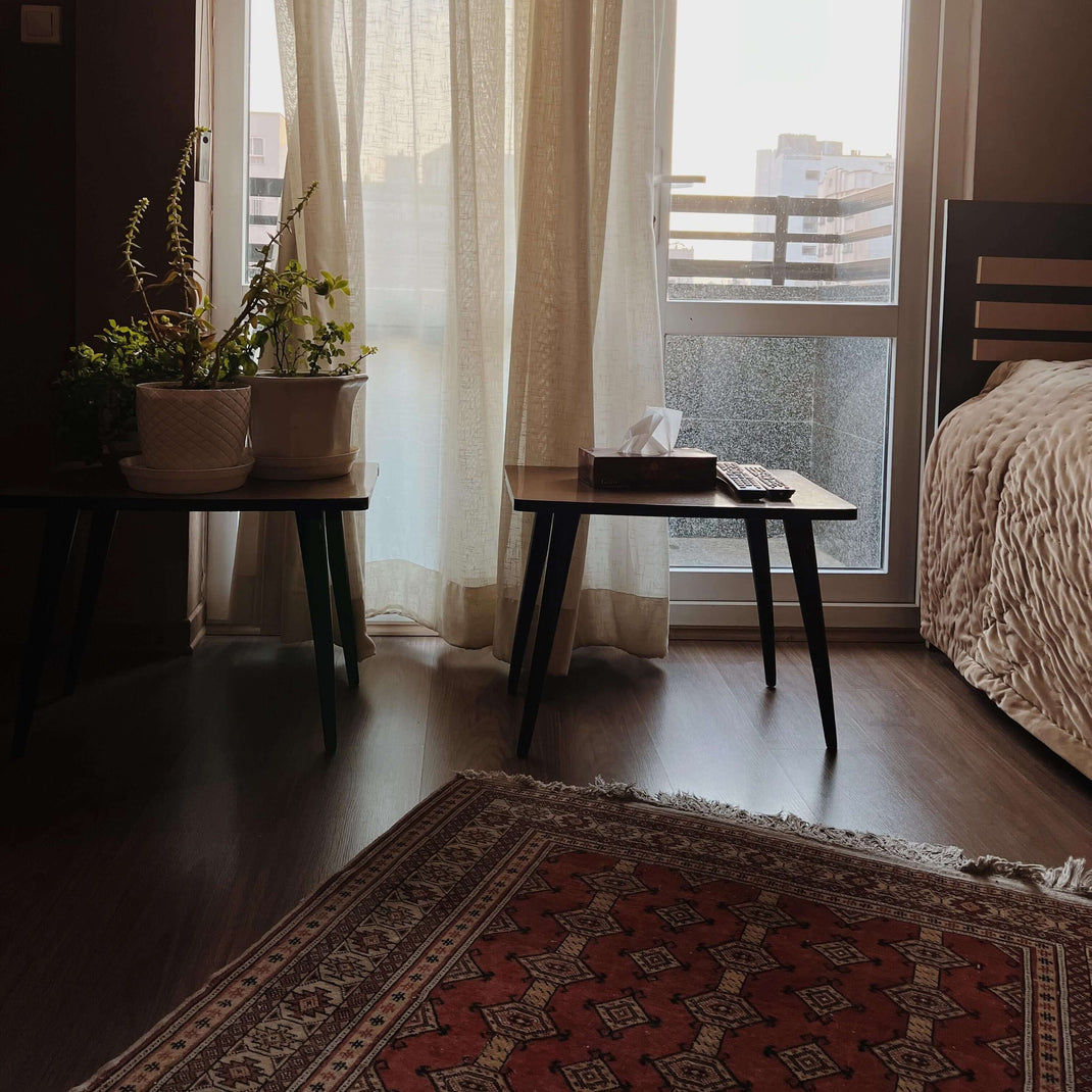 Traditional 4x6 rug beside a bed and small table in a bedroom sitting area