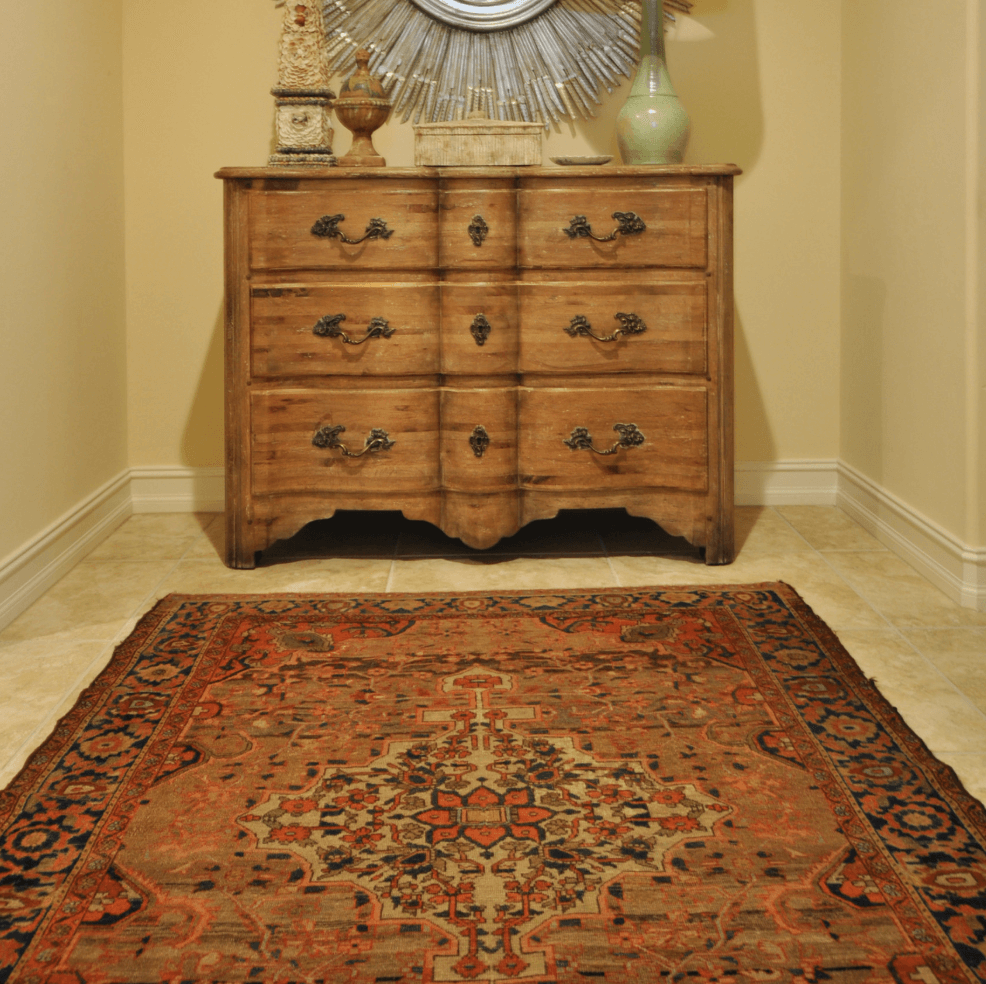 Warm-toned 6x8 rug in a traditional entryway beneath a wooden chest of drawers