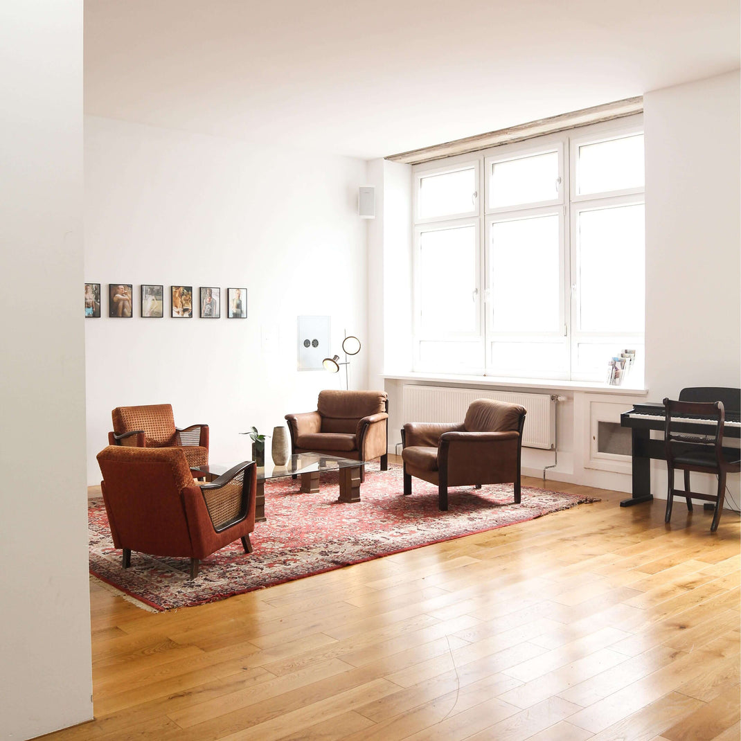 Traditional 7x10 rug defining a seating area in a spacious living room with wood flooring