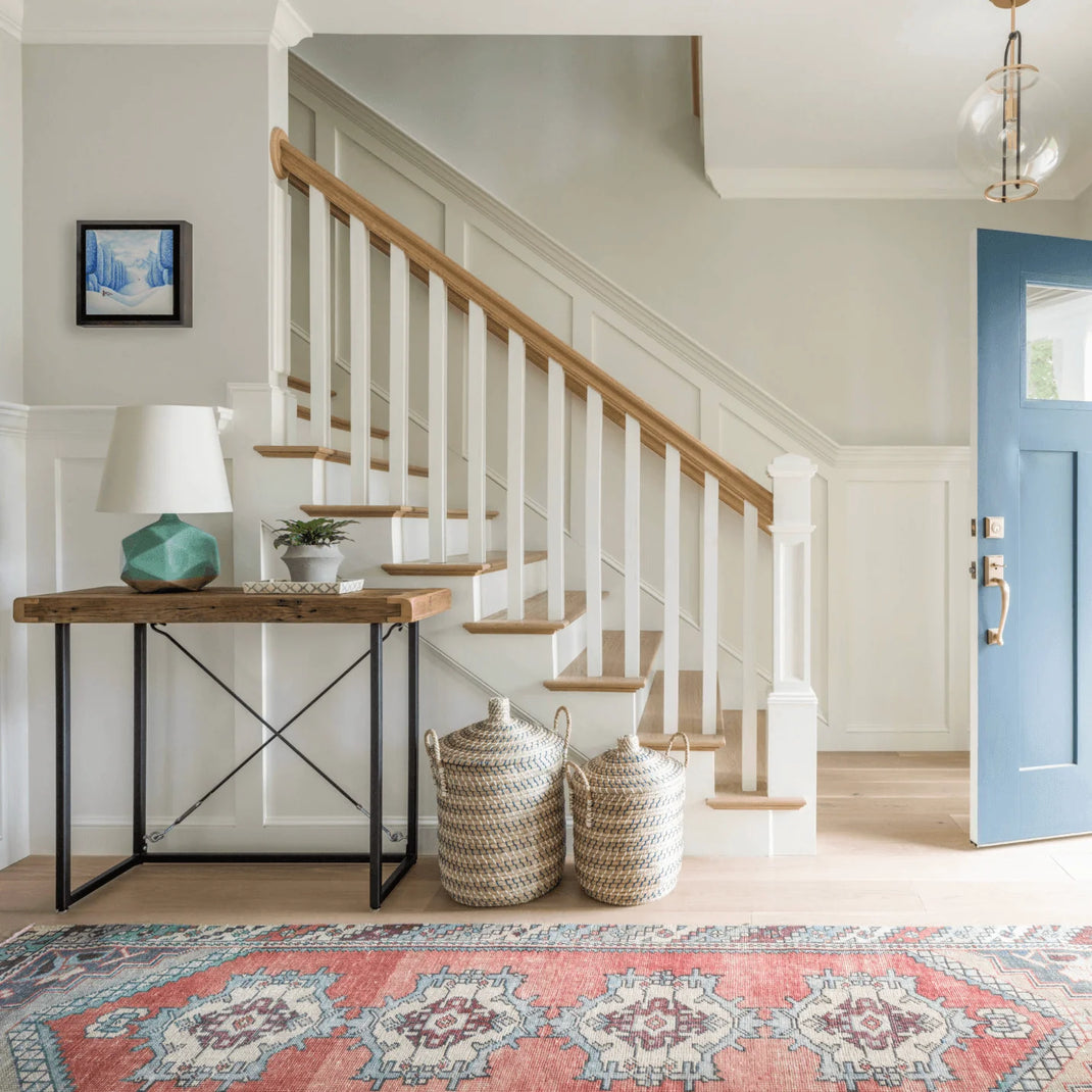 Floral 9-foot runner rug placed beside a staircase in a bright home entryway