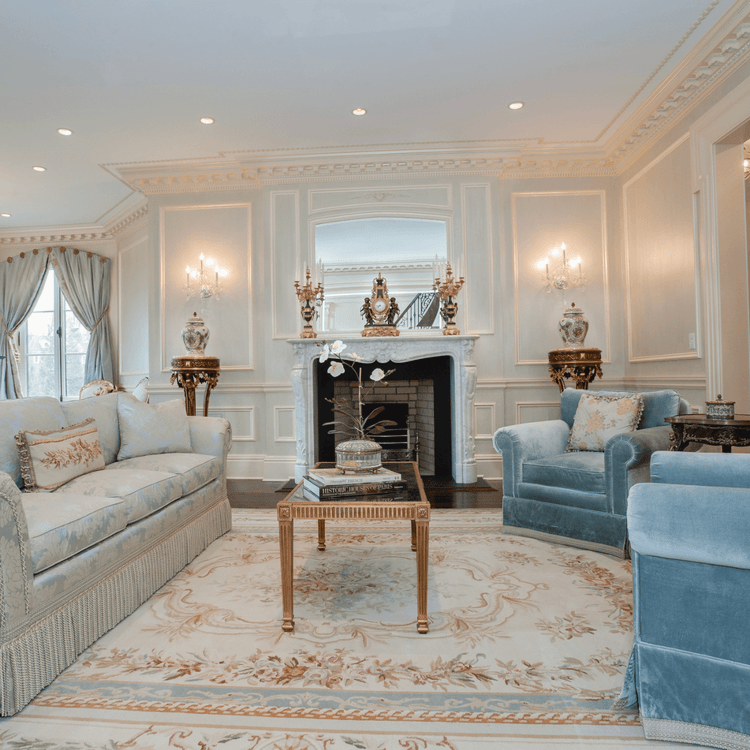 Aubusson and needlepoint kilim rug in an elegant traditional living room with pale blue seating