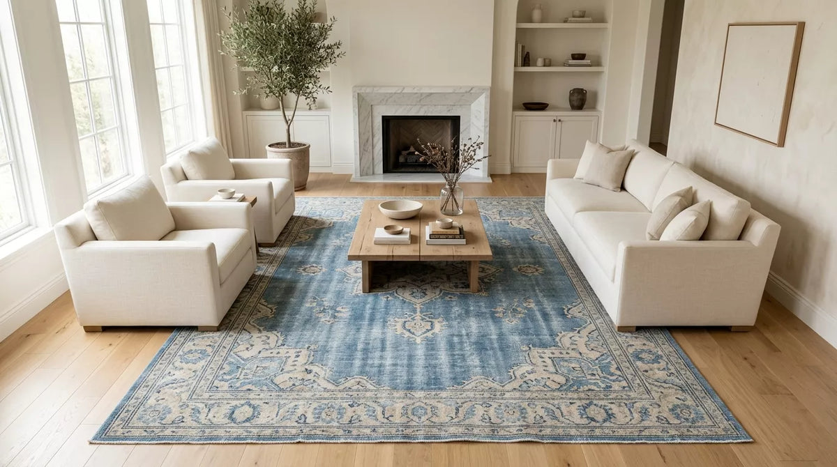 Blue vintage Oushak rug in a bright neutral living room.