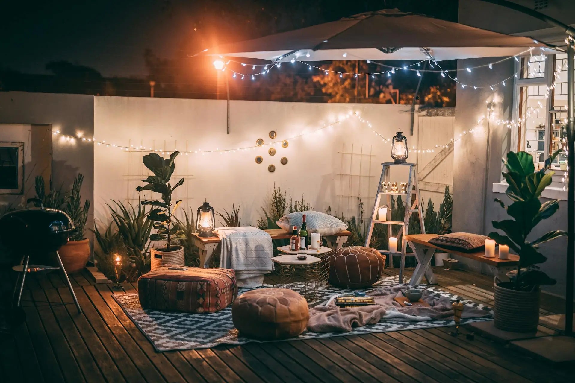 Cozy outdoor patio with a patterned area rug, string lights and lounge seating