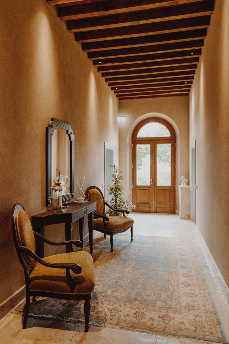 Hallway rug in a warm Mediterranean-style interior with arched doors, wood beams and a console table