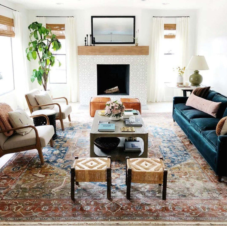 Hand-knotted area rug in a bright living room with a fireplace, blue sofa and natural wood furniture