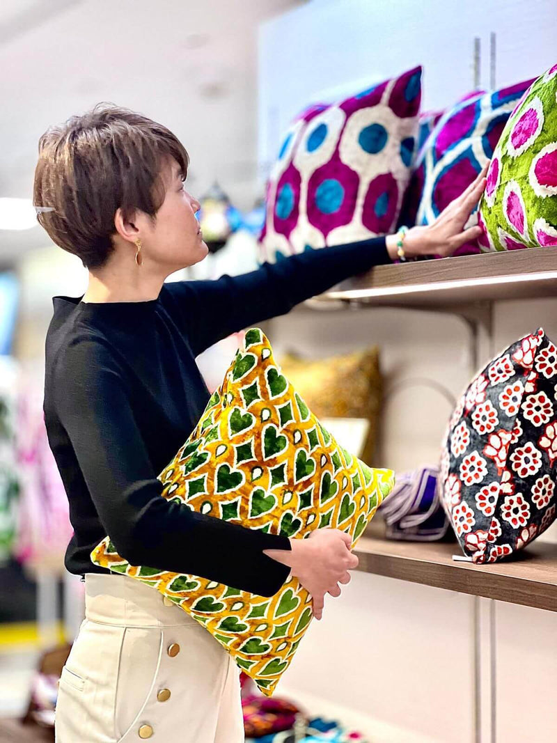 Colorful handmade patterned pillow covers displayed in a home decor shop