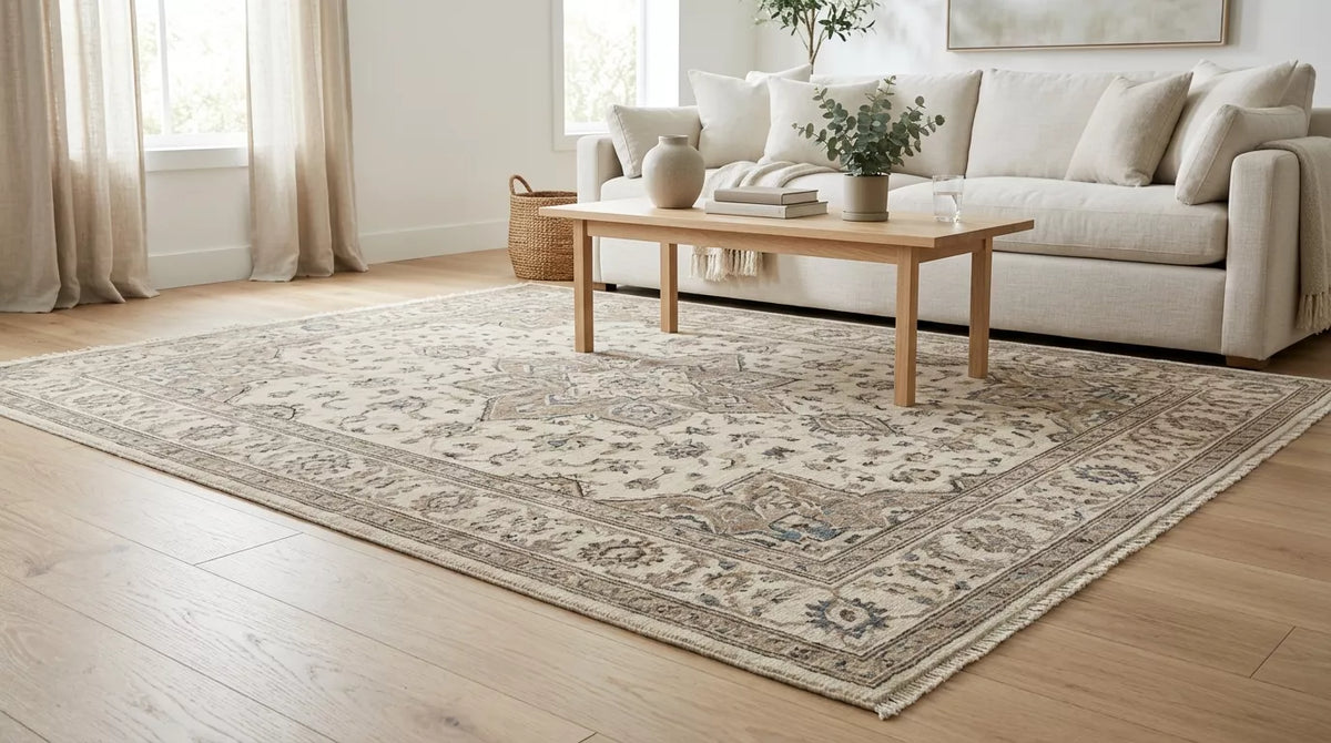 Hand-knotted wool rug in a bright neutral living room with sofa and wooden coffee table