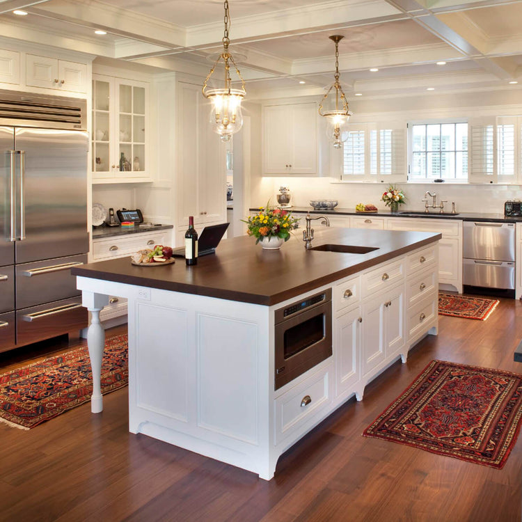 Vintage-style kitchen rug on a dark wood floor in a bright traditional white kitchen