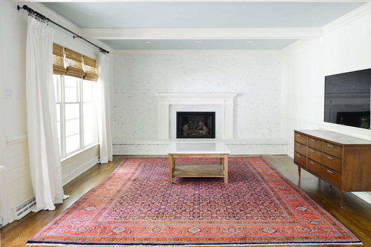 Large area rug covering a bright living room seating area with a fireplace and wooden flooring