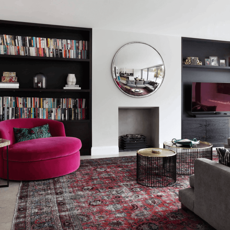 Living room rug in a modern reading room with built-in bookshelves, fireplace and accent chair
