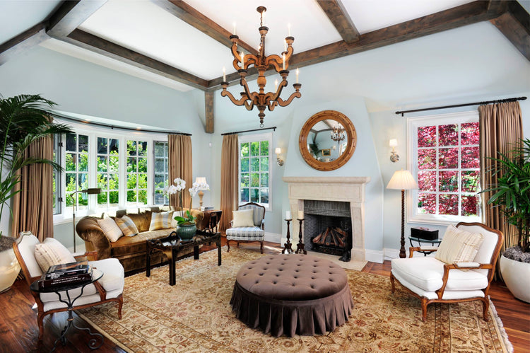 Oriental area rug in an elegant traditional living room with a fireplace, classic furniture and exposed wood beams