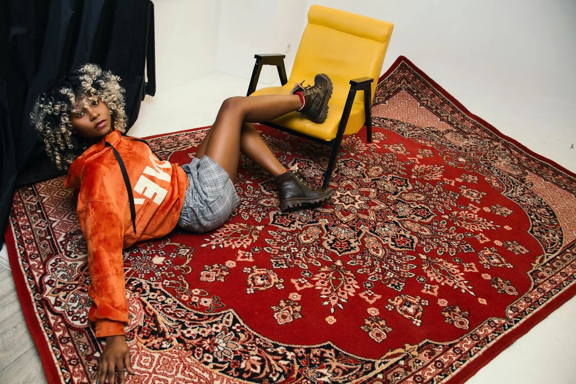 Large red Persian area rug in a modern interior with a yellow lounge chair