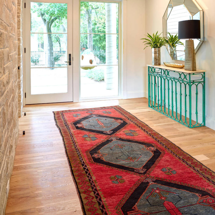 Handmade runner rug extending through a bright entryway with large windows and a console table