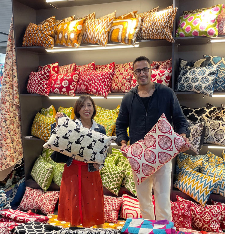Colorful silk and velvet pillow covers displayed in a textile showroom with patterned cushions