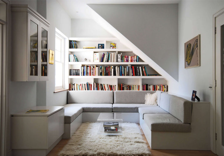 Plush Tulu rug in a modern under-stair reading nook with built-in bookshelves and a gray sectional sofa