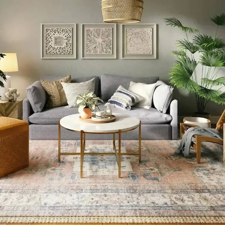 Faded vintage area rug in a neutral living room with a gray sofa